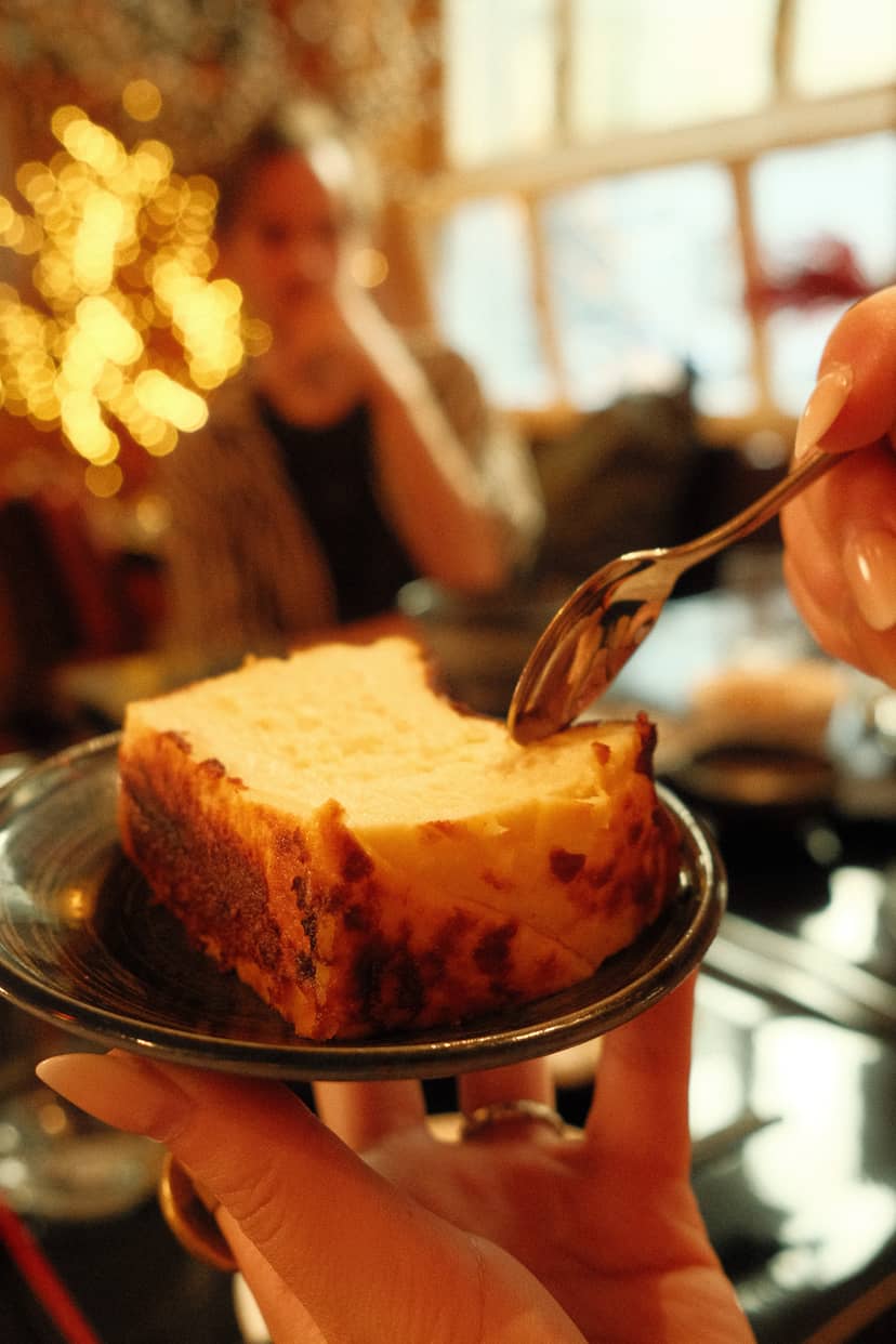 SHOKUDO Izakaya server pouring sauce over a slice of cake in Zürich during a festive dining experience.